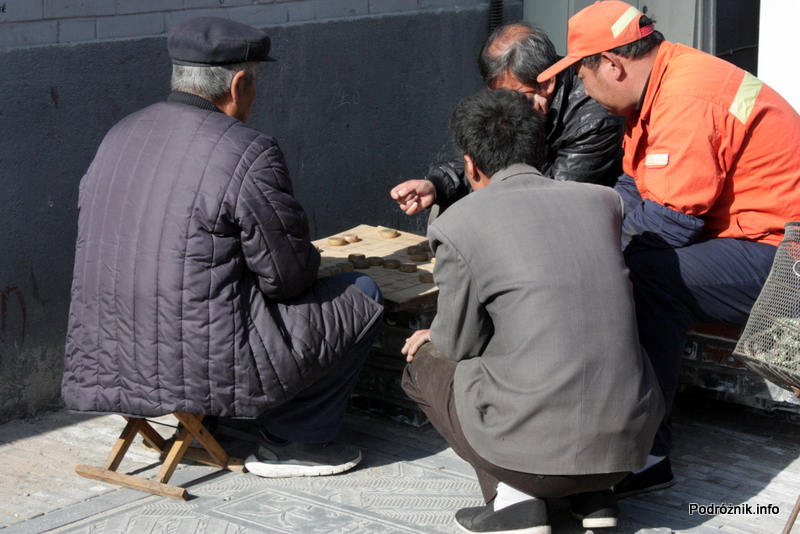 Chiny - Pekin - mężczyźni grający przy stoliku ustawionym na chodniku - kwiecień 2013