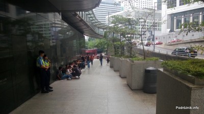 Chiny - Hongkong - strajkujący pracownicy siedzą pod ścianą budynku - kwiecień 2013