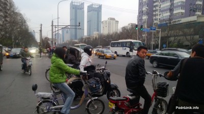 Chiny - Pekin - okolice dworca kolejowego Dongzhimen - ludzie na jednośladach czekający na przejazd - kwiecień 2013